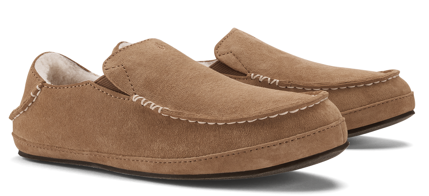 A pair of brown suede moccasin slippers with decorative stitching.