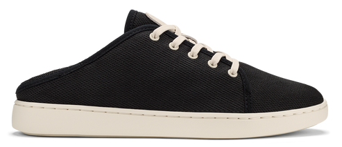 A slip-on sneaker featuring black canvas and white laces.