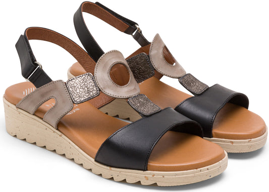 A pair of two-toned black and tan sandals with circular decor and ankle strap.