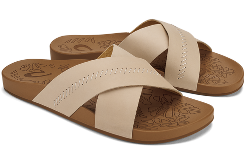 Pair of beige criss-cross strap slide sandals with brown soles.