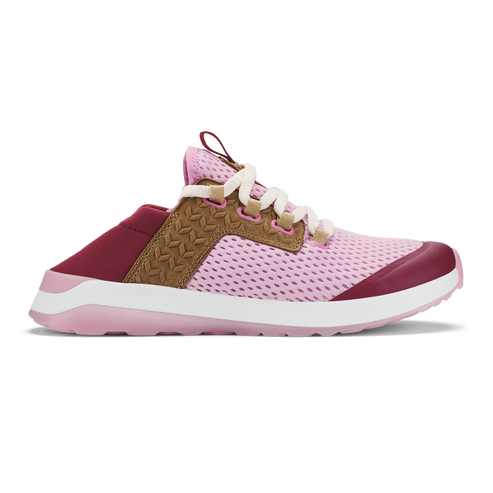 A slip-on style sneaker in pastel pink mesh with a tan suede-like mid-section featuring a woven pattern, dark berry-colored accents on the toe and heel, and a thick white and pink sole.