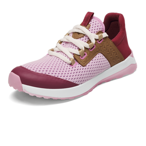 A light pink athletic sneaker featuring a breathable mesh upper, a dark burgundy toe cap and heel collar, and brown side paneling with a geometric textured pattern. The shoe includes white laces, a padded tongue, and a thick, white foam midsole with a light pink outsole.