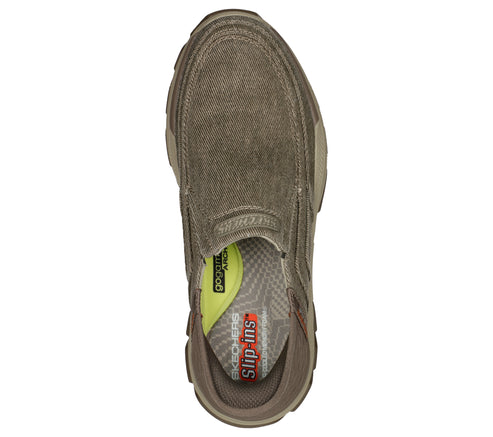 Top-down view of a slip-on shoe with a brown canvas upper, showcasing a cushioned insole labeled 'Skechers Slip-ins' and 'Goodyear.'