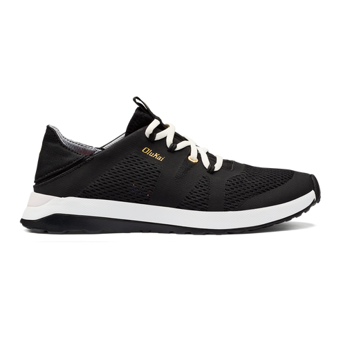 Black shoe with white laces and white midsole, with 'OluKai' in gold on side.