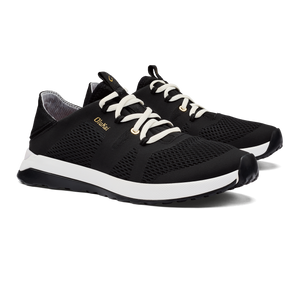 A pair of black running shoes with white laces and a white sole, with the word "OluKai" on the side.