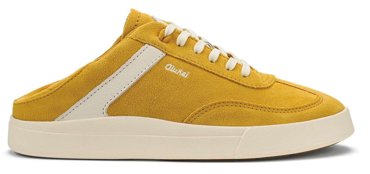 Yellow suede sneaker with white laces and sole, white stripe and the word "OluKai" written on the side.