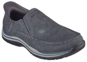 Slip-on gray casual shoe with 'SKECHERS' stitched near the top, decorative stitching near the sole, and a padded heel.