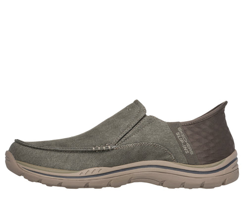 Olive green slip-on shoe with brown soles and textured brown heel cup, text reads "SKECHERS SLIP-INS".