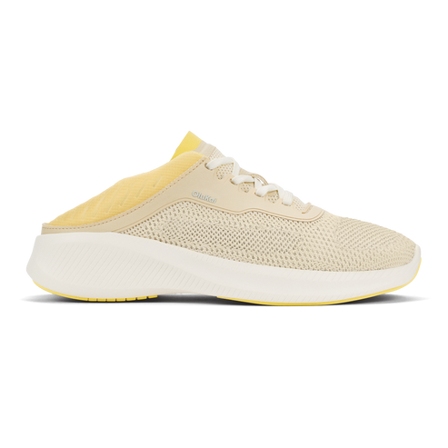 A slip-on sneaker with a beige knit mesh upper, a white chunky midsole, and yellow interior lining and outsole accents.
