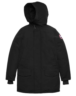 A black, knee-length, hooded parka with a central zipper hidden by a snap-button placket, two large flap pockets at the waist, and ribbed cuffs.