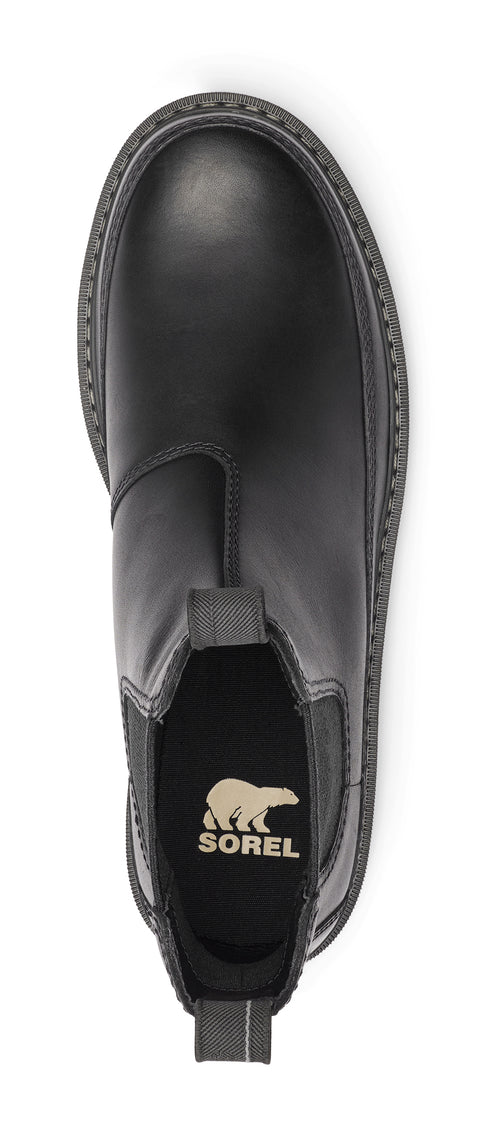 a black Chelsea boot with a thick sole, showing the insole with a logo.