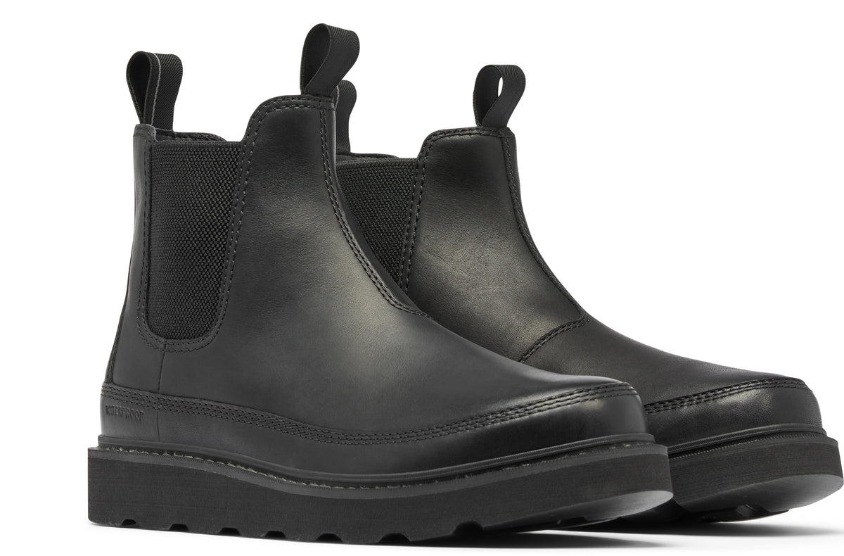 A pair of black, ankle-high chelsea boots with a platform sole and loop pull tabs.