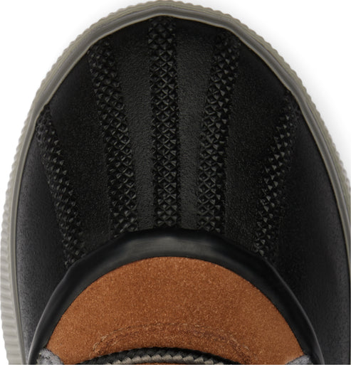 Close-up of a black boot's toe with textured rubber and brown suede.