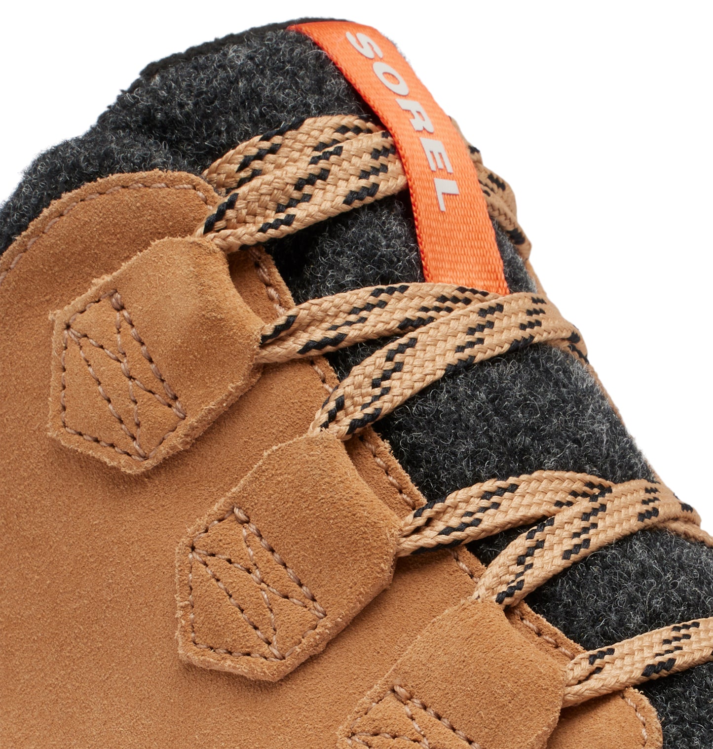 Close-up of brown suede hiking boot with fabric eyelets and patterned laces; orange brand label on dark gray felt collar.