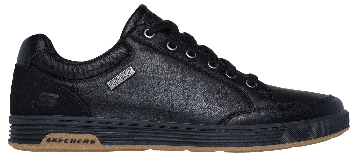 A black leather sneaker with black laces and a brown sole.