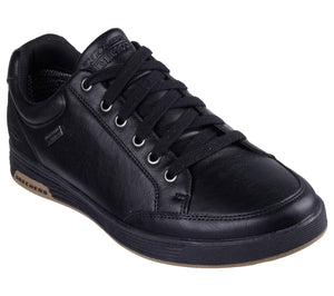 A low top, black leather sneaker with black laces and silver eyelets.