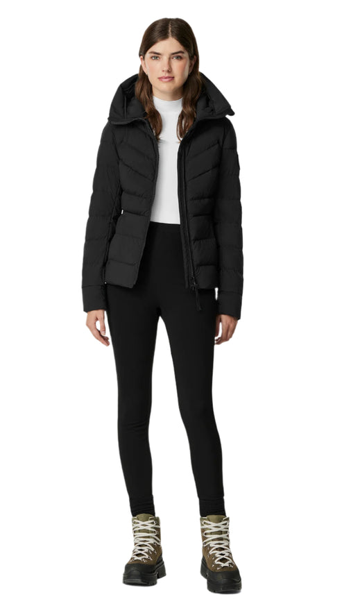 A woman wearing a black padded jacket, black leggings, and hiking boots.