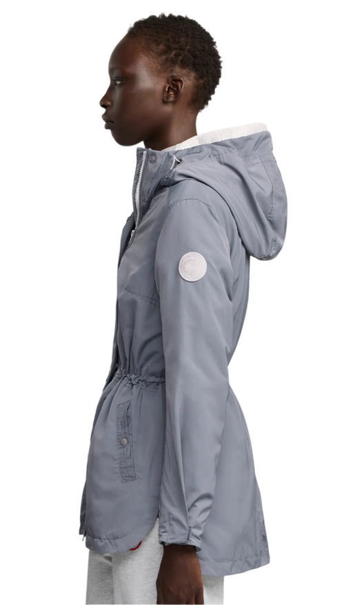 Side view of a woman wearing a gray raincoat with a hood.