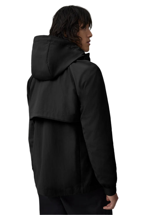 Black hooded jacket on person from the back.