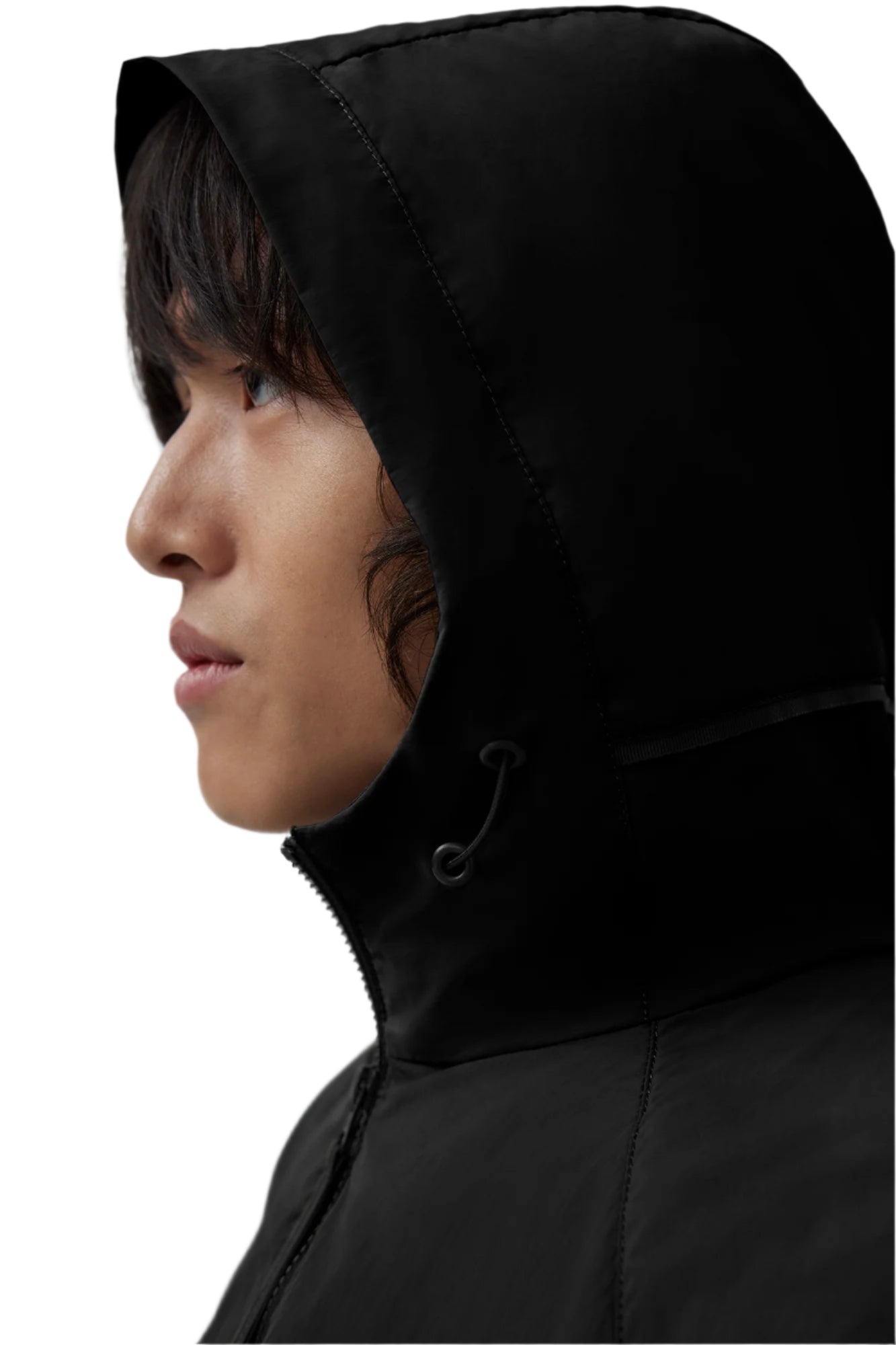 Side view of a person wearing a black jacket with a large hood.