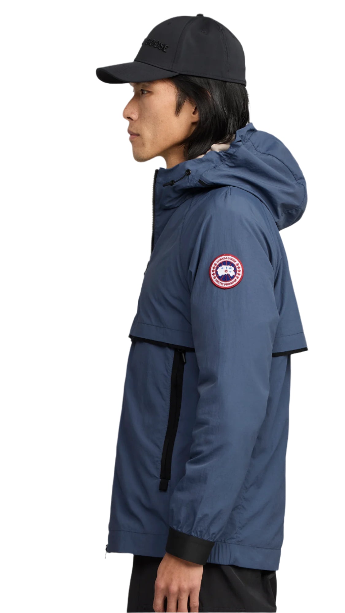 A person wearing a blue hooded jacket and black cap.