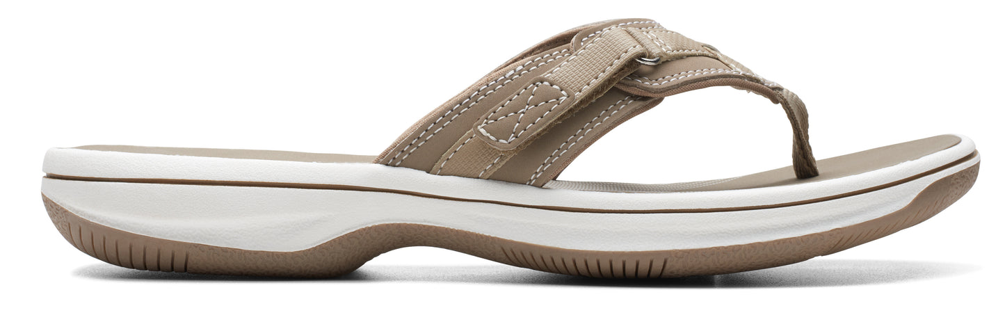 A women's light brown sandal with a thong toe and a white sole.