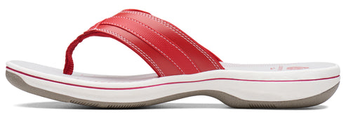 A red sandal with white sole and grey outsole.