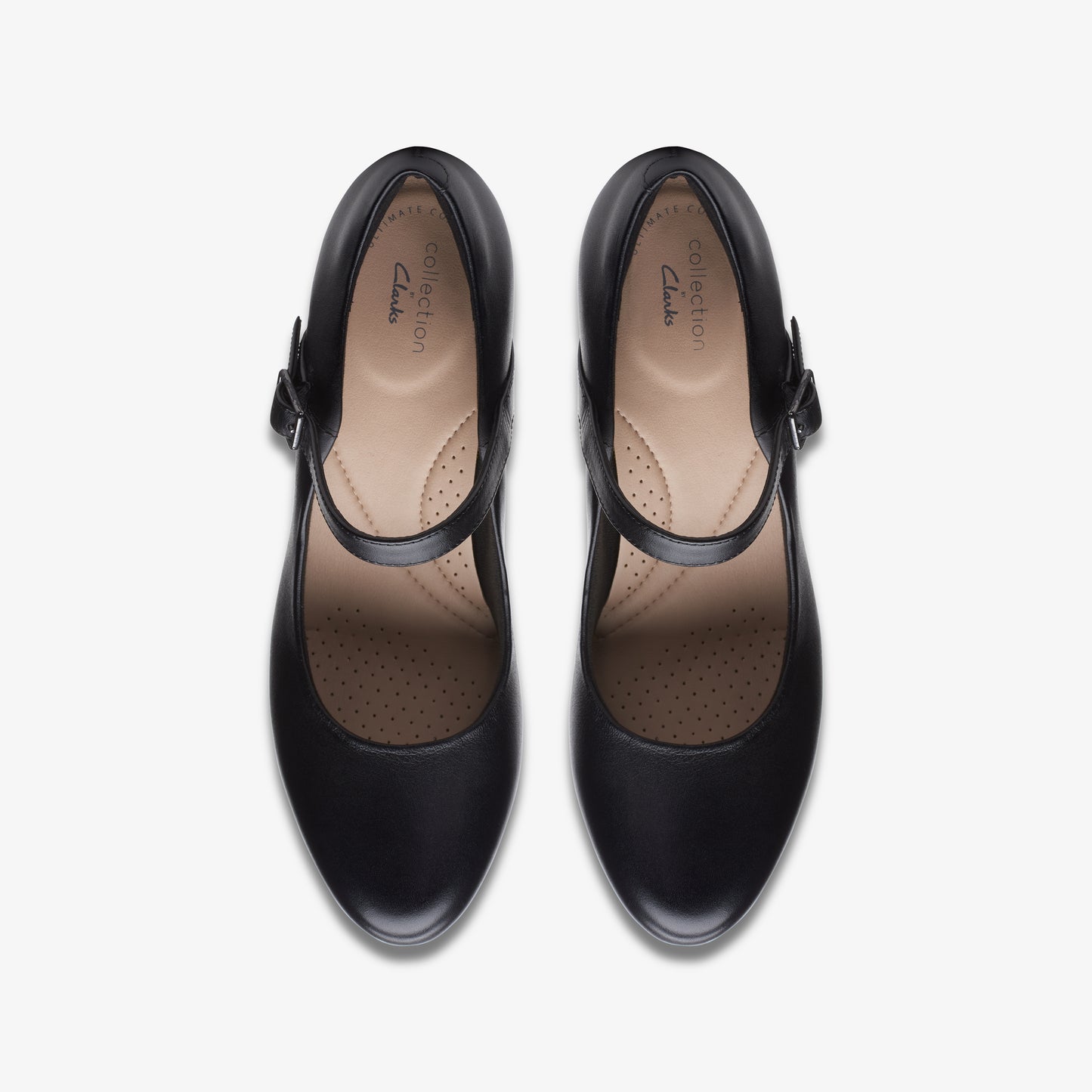Overhead view of two identical black Mary Jane shoes with a strap, rounded toe, and a light-colored insole.