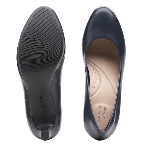 Two navy leather pumps, sole and inner view, brand "collection Clarks" visible inside.