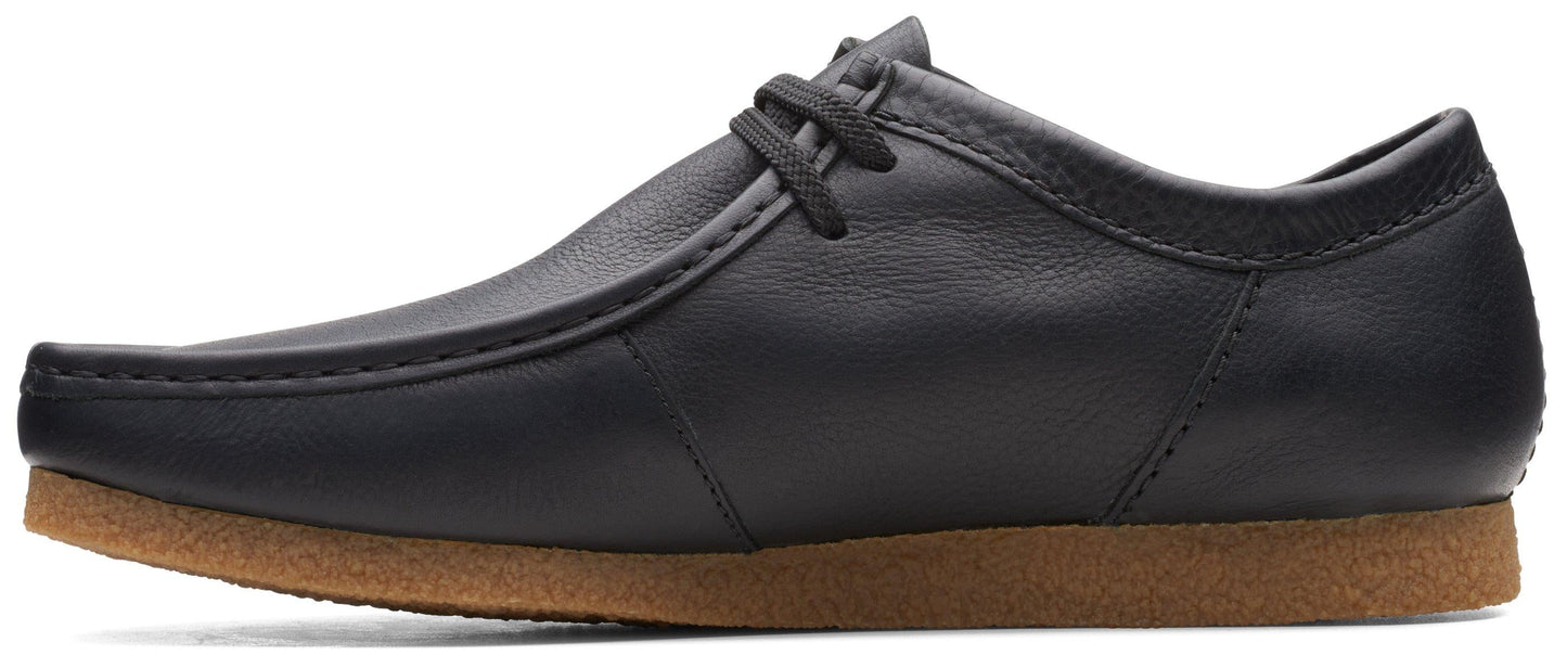 A black leather lace-up dress shoe with a brown sole.