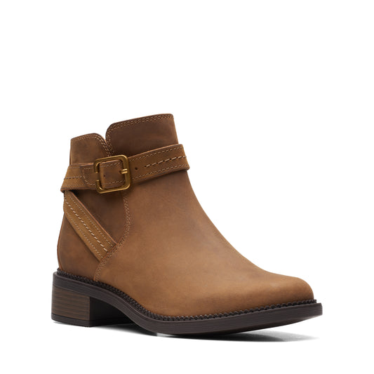 Tan leather ankle boot with strap and buckle.