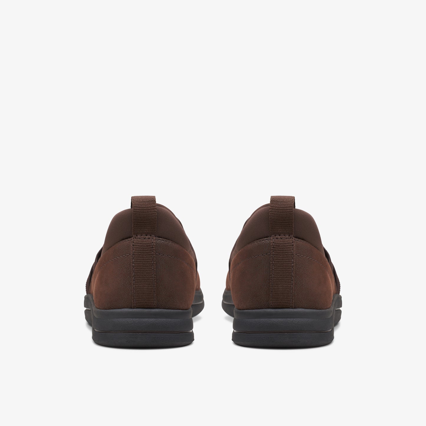 Back view of two brown slip-on shoes with black soles.