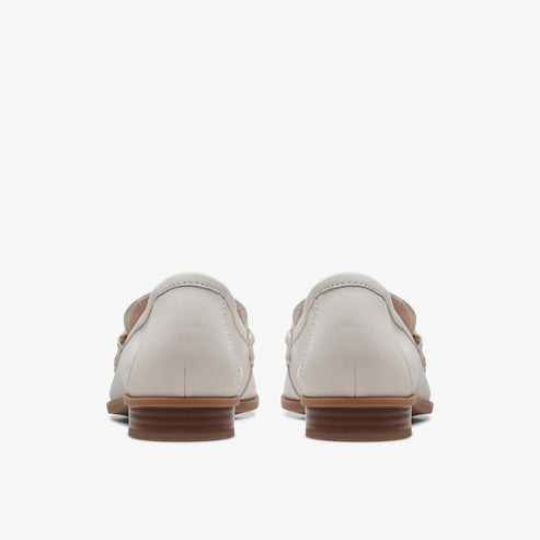 Pair of gray loafers with brown soles, seen from the back.