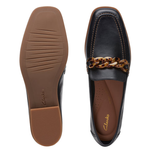 Black leather loafers with tortoise chain detail, showing both the interior and sole.