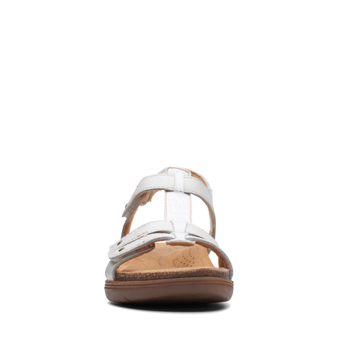 White T-strap sandal with adjustable straps and a brown sole, front view.