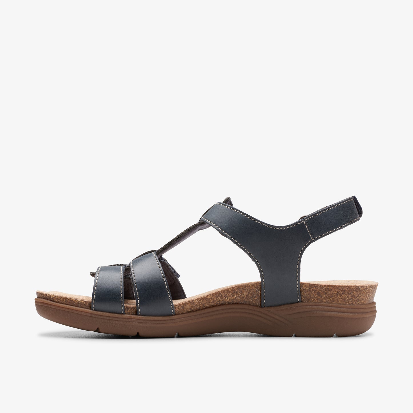 A side view of a dark blue leather sandal with a flat brown cork sole.