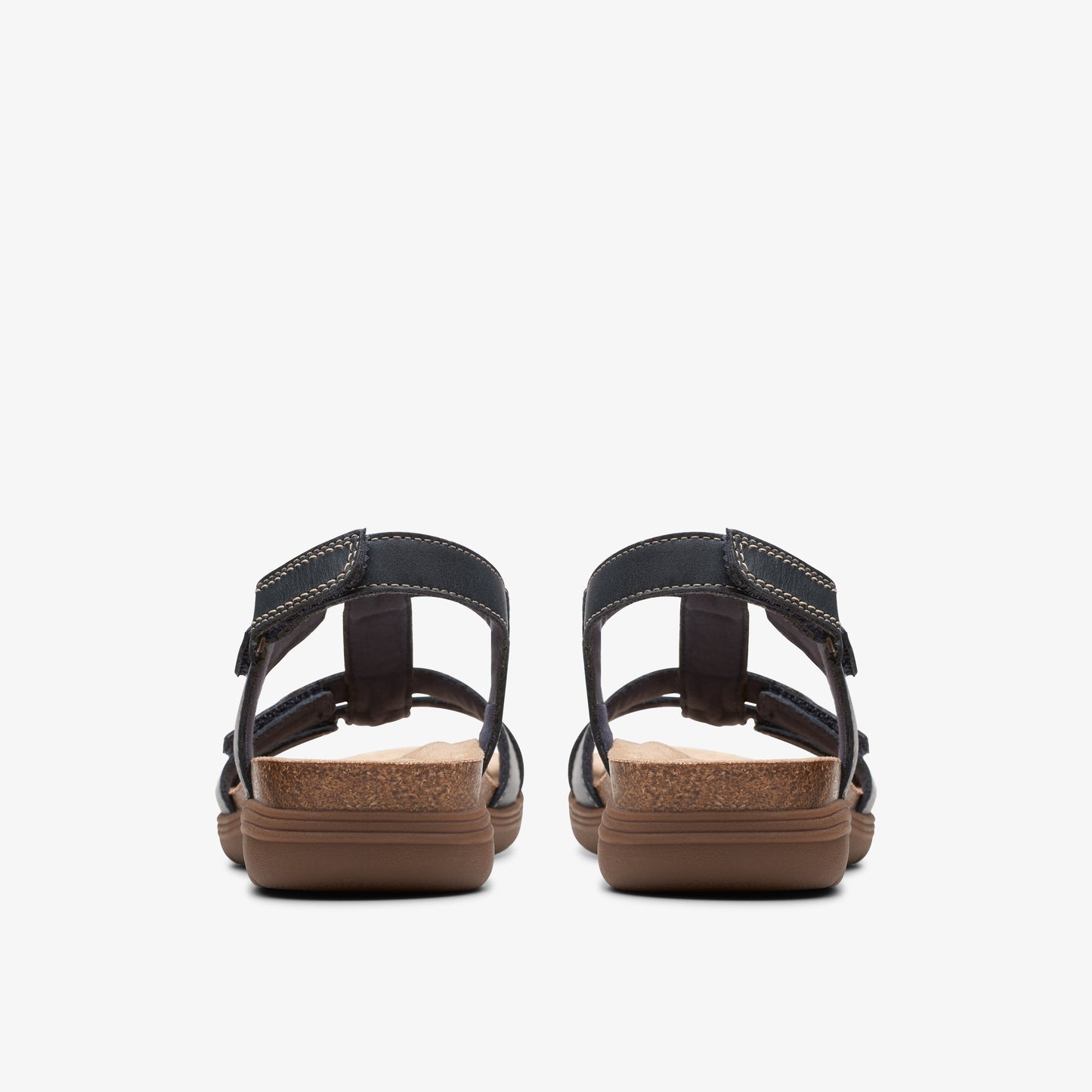 Rear view of sandals with black straps and brown soles.