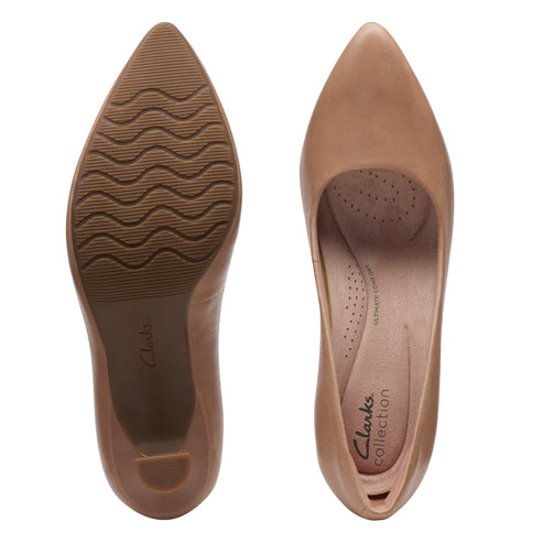 Pair of caramel-colored women's pumps showing insole with visible text "Clarks collection" and sole with wave-like treads.