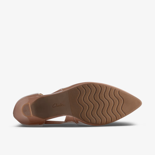 Underside view of tan shoe with a heel and wavy sole.