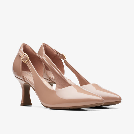 Pair of nude patent leather pumps with stiletto heels and ankle straps.