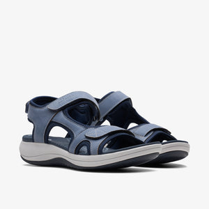 Two light blue sandals with velcro straps, on a white and black sole.