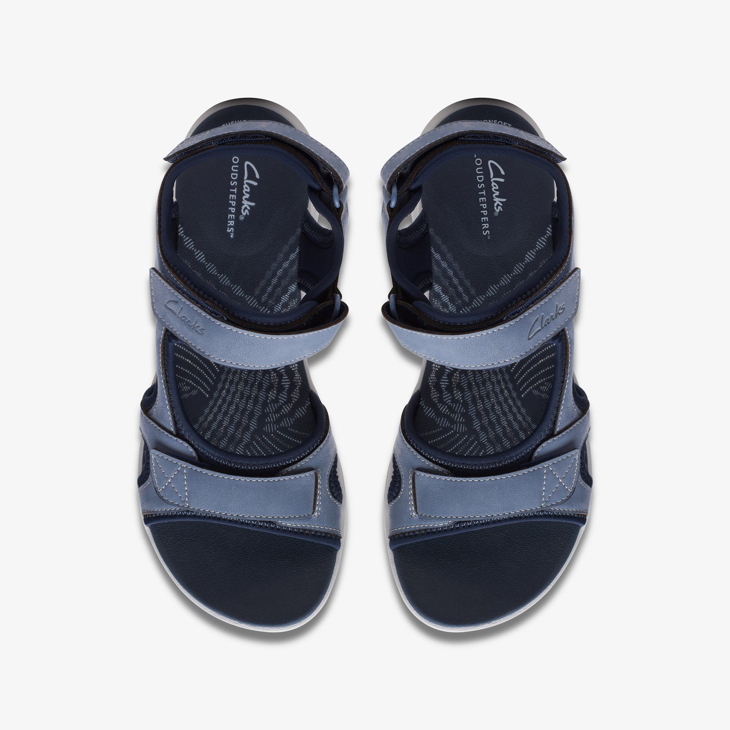 Overhead view of two blue hook-and-loop closure sandals with "Clarks CLOUDS STEPPERS" printed on the insole.