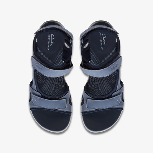 Overhead view of two blue hook-and-loop closure sandals with "Clarks CLOUDS STEPPERS" printed on the insole.