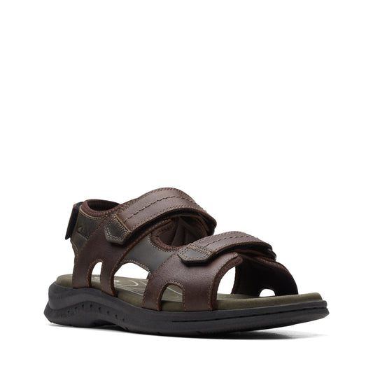 A pair of brown leather sandals with velcro straps and black soles.