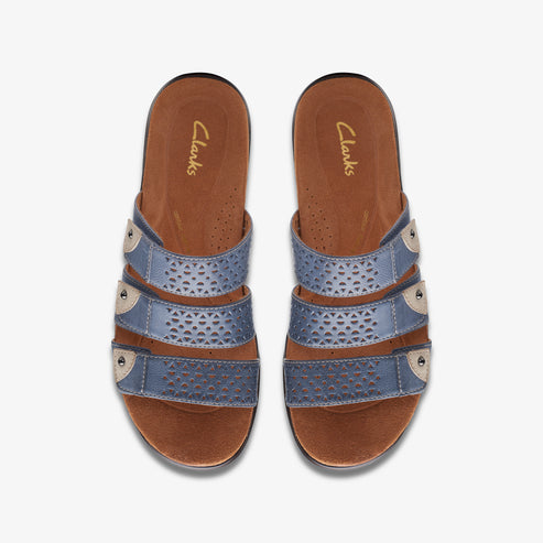 Pair of flat, brown-soled sandals with three decorative blue straps, featuring cut-out geometric patterns, connected by beige circles.