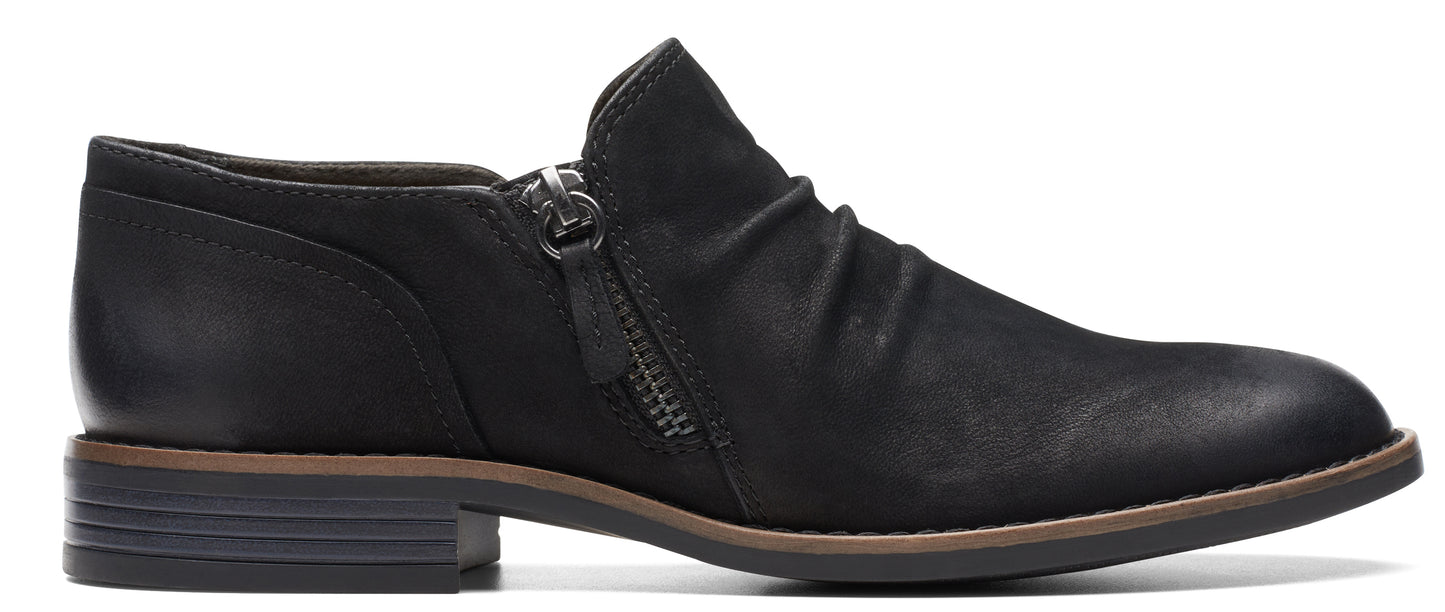 A black low-heeled shoe with a side zipper.