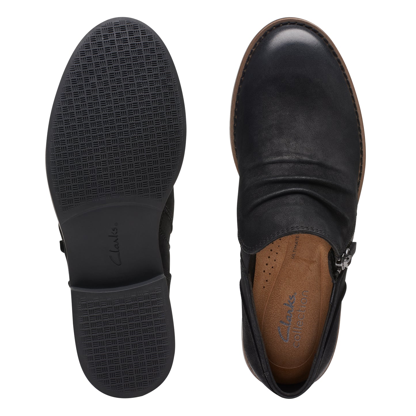 A pair of black leather ankle boots, one showing the rubber sole and the other showing the interior.