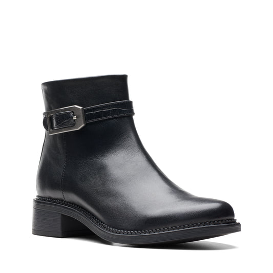 A black, leather-look ankle boot with a low heel and a buckled strap.