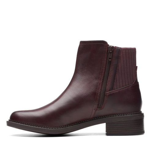 Side-view of a dark red, ankle-high, leather boot with a side zipper and a low heel.
