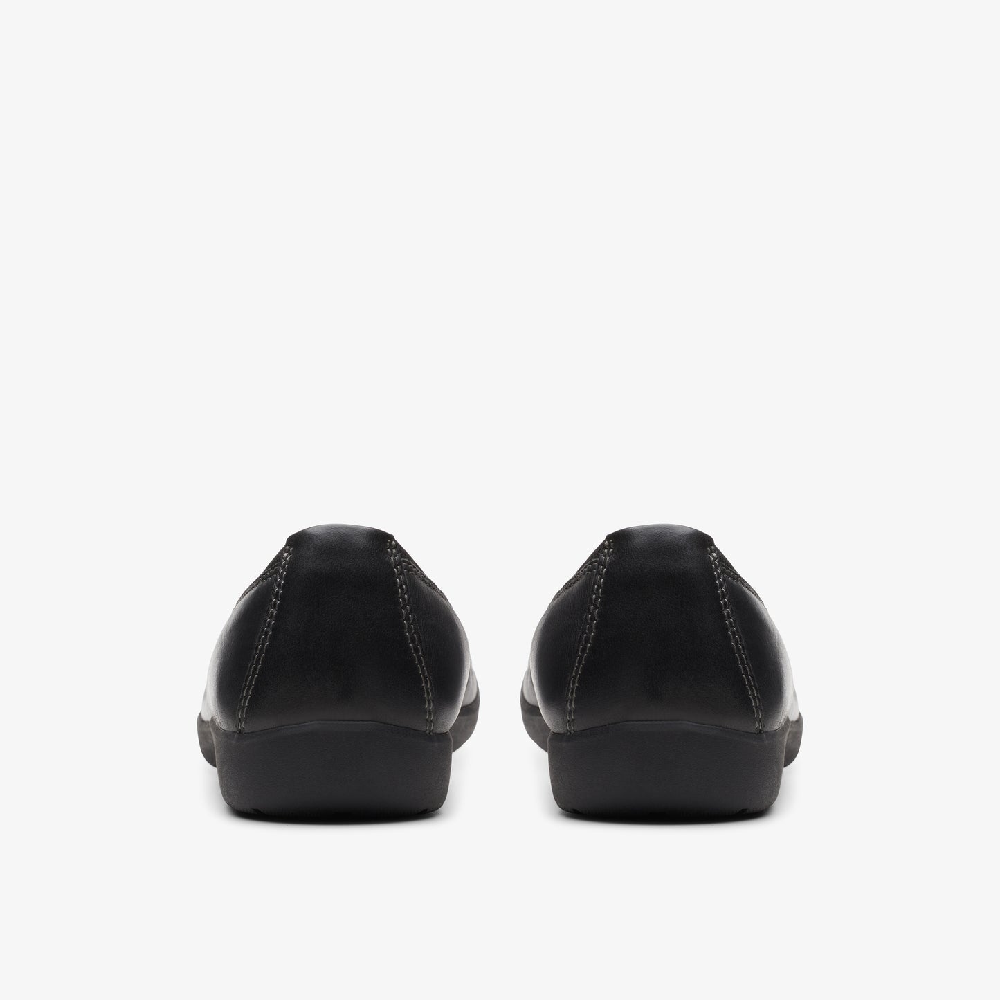 Pair of black closed-toe leather flat shoes, viewed from the back.